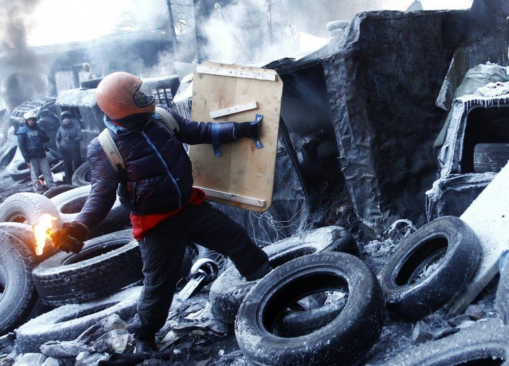 An anti-government protester holds a Molotov cocktail at a barricade at the site of clashes with riot police in Kiev