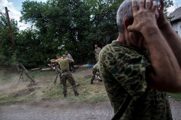 Бойцы ополчения ведут огонь из минометов во время боя за пограничный населенный пункт Кожевня под Снежным.