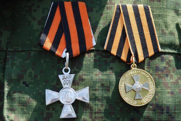 Георгиевский крест ДНР № 001, который получил ополченец батальона «Викинги» ДНР за сбитый украинский штурмовик Су-25, и медаль «За оборону Славянска».