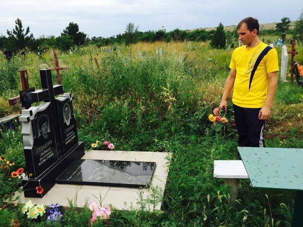 © РИА Новости Денис Судаков на могиле своих родителей, погибших в тот же день, что и Стенин